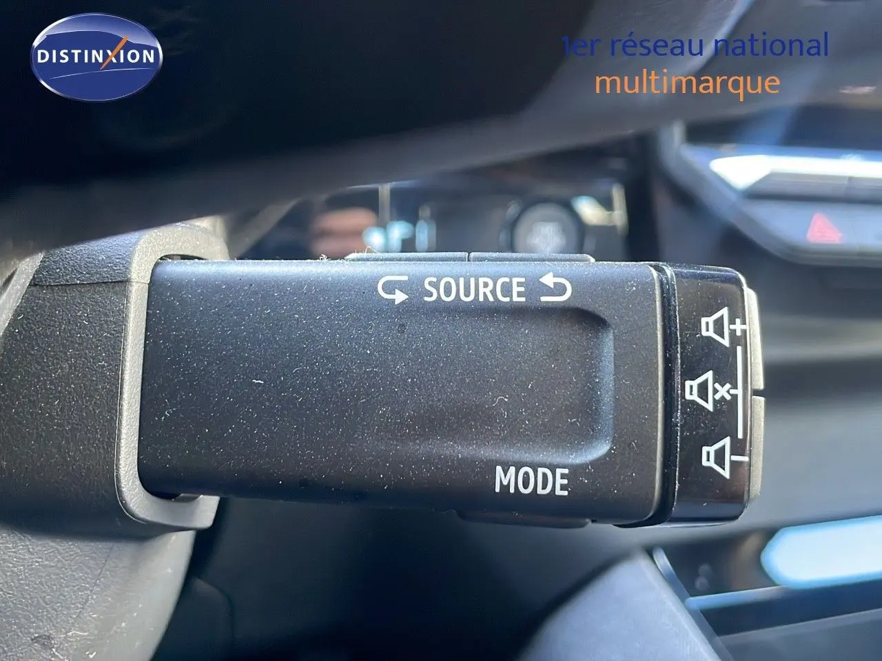 Gros plan sur la commande au volant du Renault Austral blanc glacier, montrant les boutons source et mode.