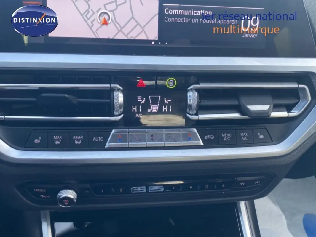 Vue rapprochée du tableau de bord de la BMW Série 3 G20 noire, mettant en valeur les commandes de climatisation et l'écran central.