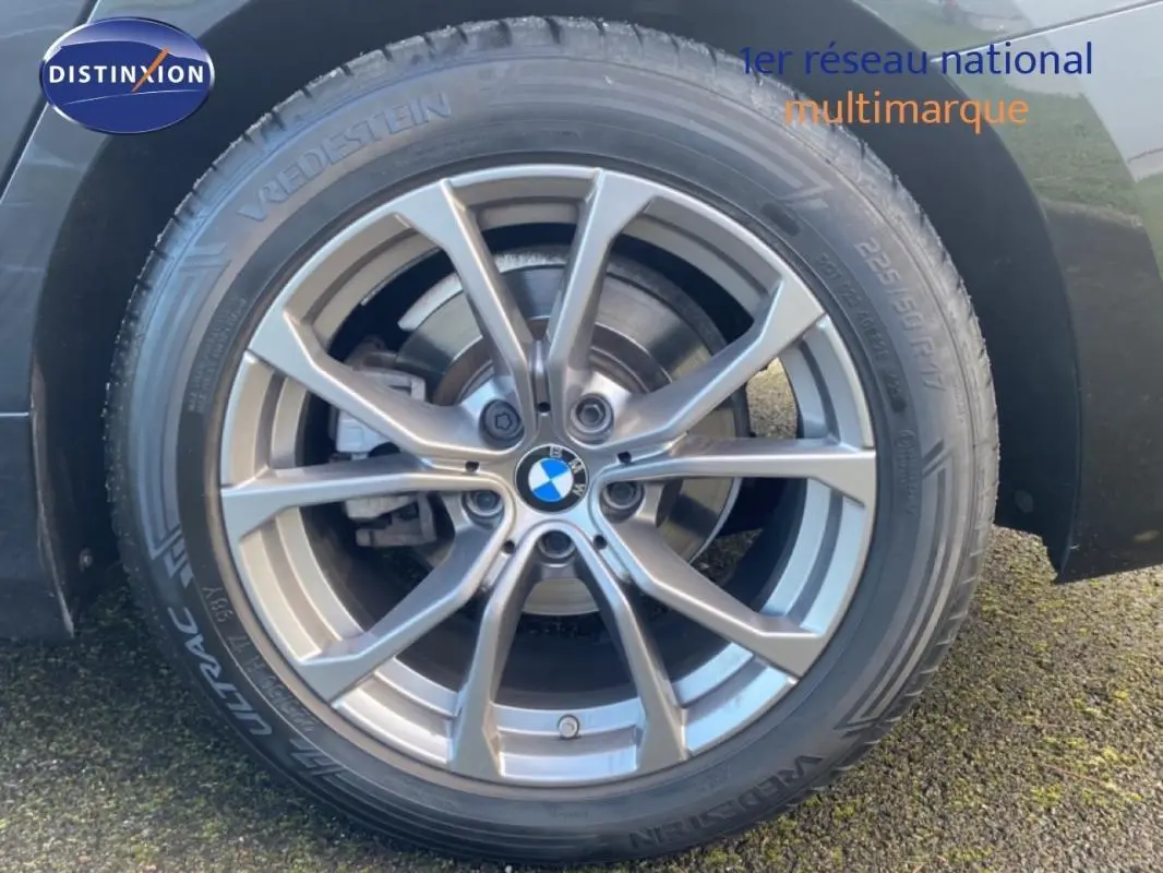 Gros plan sur la jante alliage 17 pouces argentée d’une BMW Série 3 noire, vue côté arrière droit.