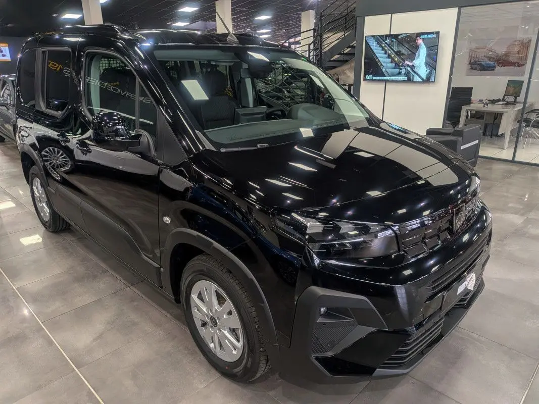 Vue 3/4 avant d’un Peugeot Rifter Allure 2026 noir Perla Nera, avec calandre et optiques modernes en showroom.