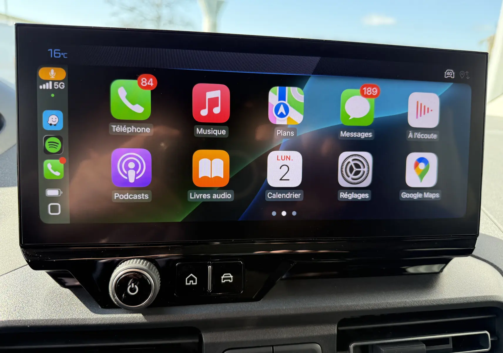 Vue intérieure frontale du tableau de bord du Peugeot Rifter Allure 2026, avec volant compact et écran tactile central.