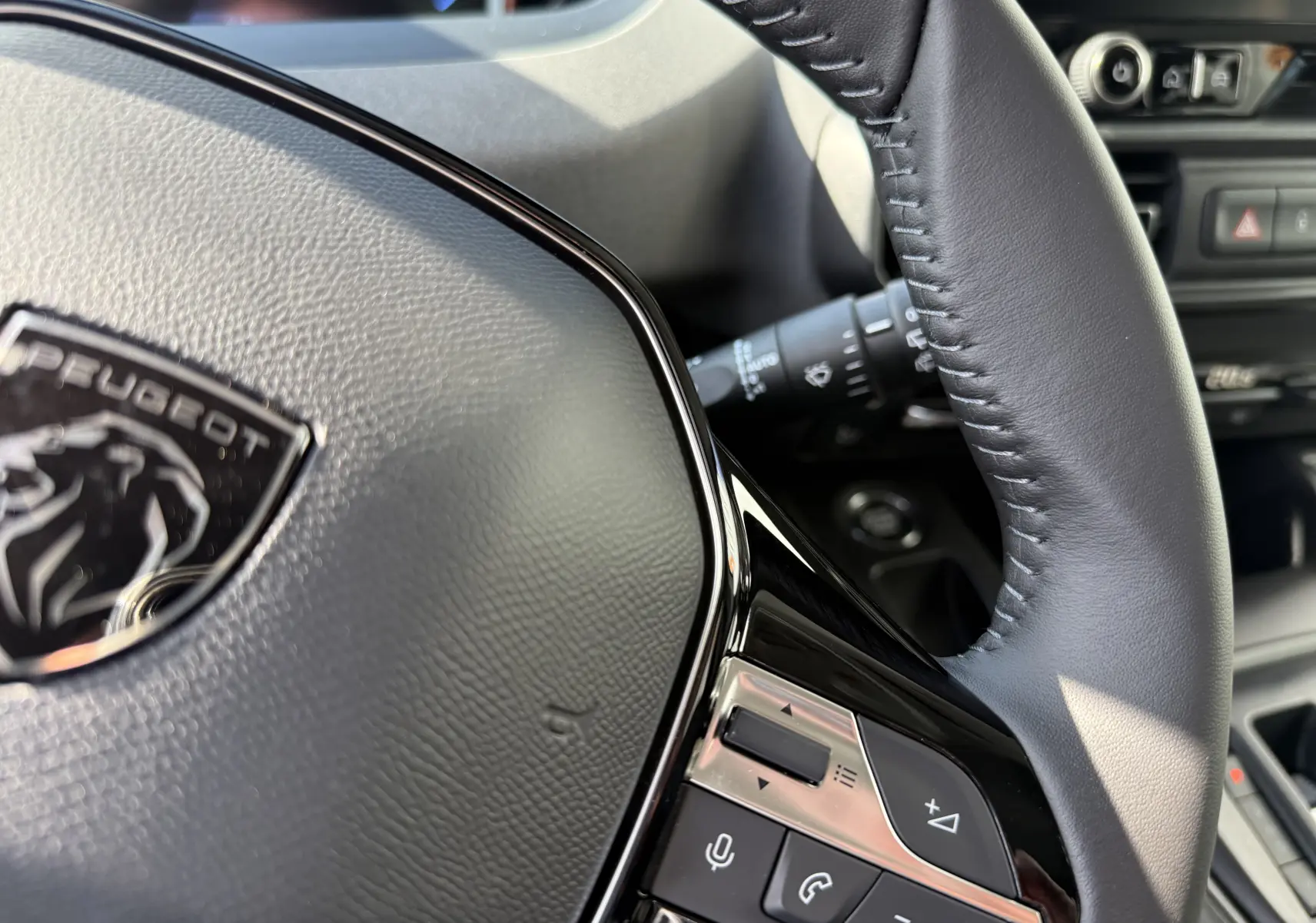 Gros plan sur la console centrale du Peugeot Rifter noir Perla Nera, avec clé, boutons boîte auto et climatisation digitale.