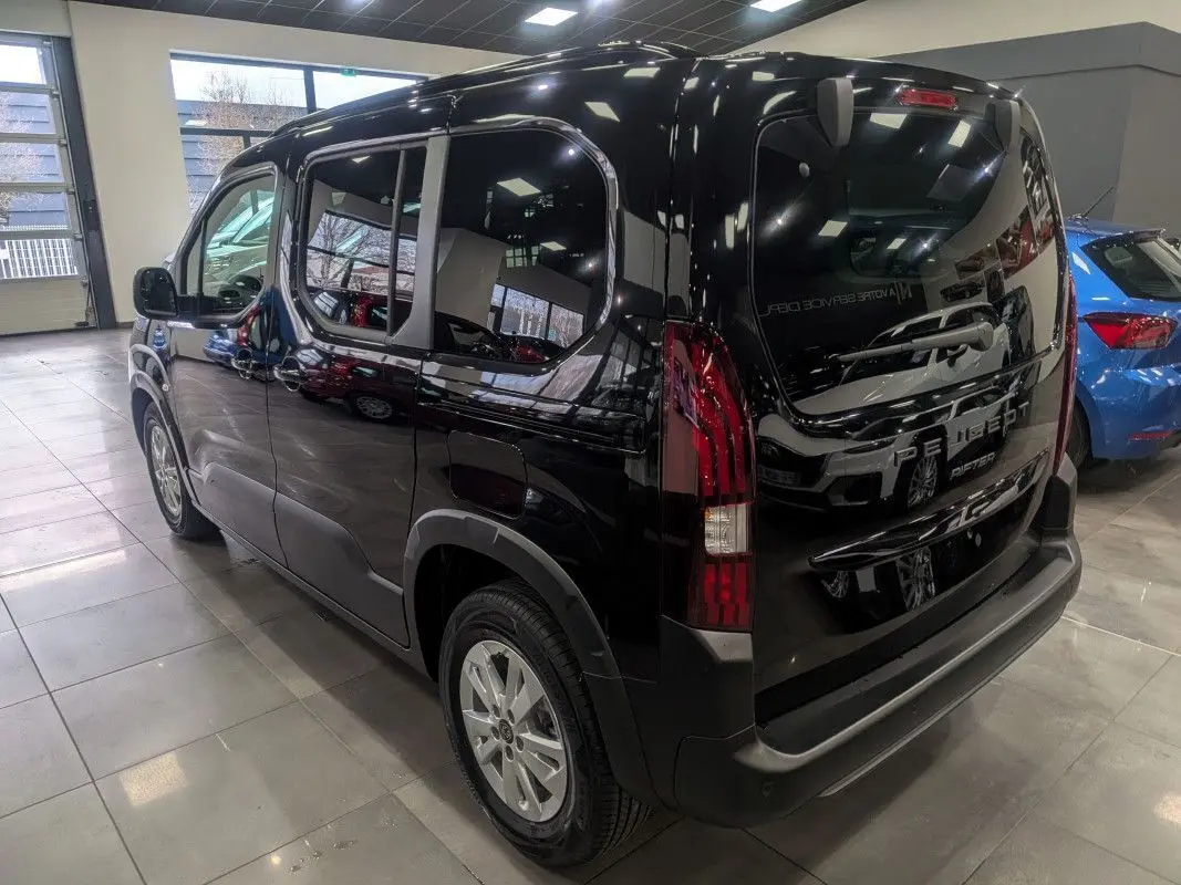 Vue 3/4 arrière droite d’un Peugeot Rifter Allure 2026 noir Perla Nera avec feux arrière LED et jantes alliage.