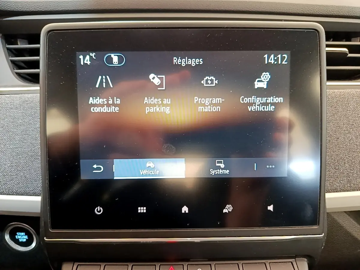 Écran tactile central de la Renault ZOE gris clair affichant le menu réglages avec options d’aides à la conduite et parking.