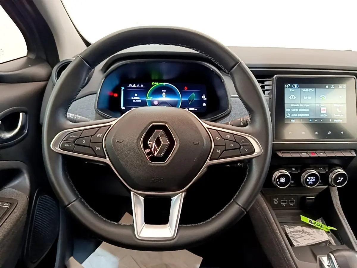 Vue intérieure centrée sur le volant noir et le tableau de bord numérique de la Renault ZOE gris clair MY22.
