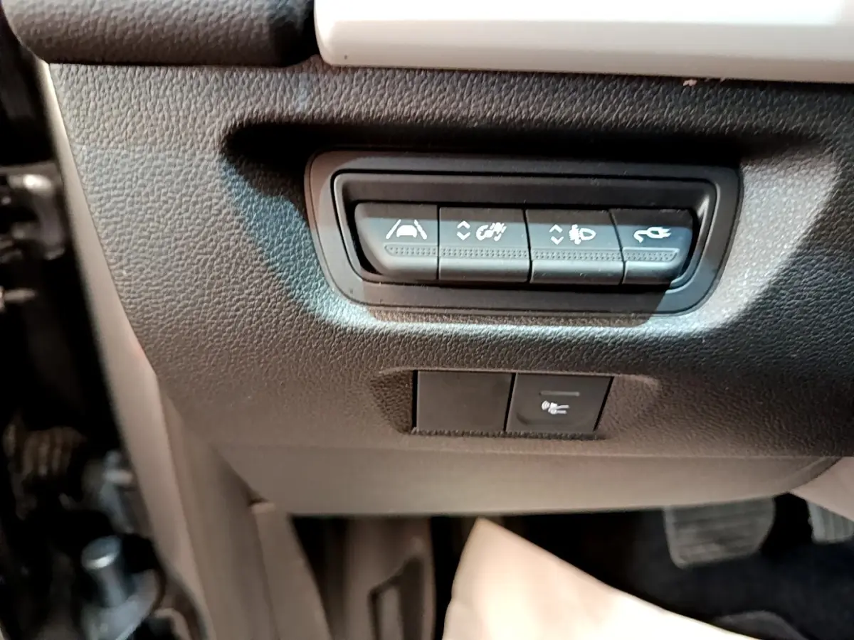 Gros plan sur les boutons de commande situés sous le tableau de bord côté conducteur de la Renault ZOE gris clair électrique.