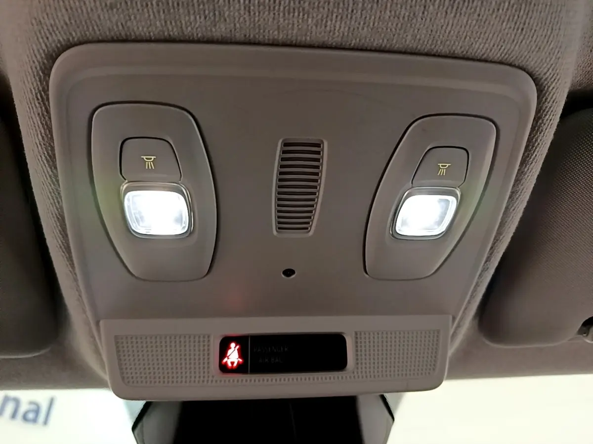 Plafonnier intérieur allumé avec deux lampes de lecture et témoin de ceinture de sécurité dans une Renault ZOE gris clair.