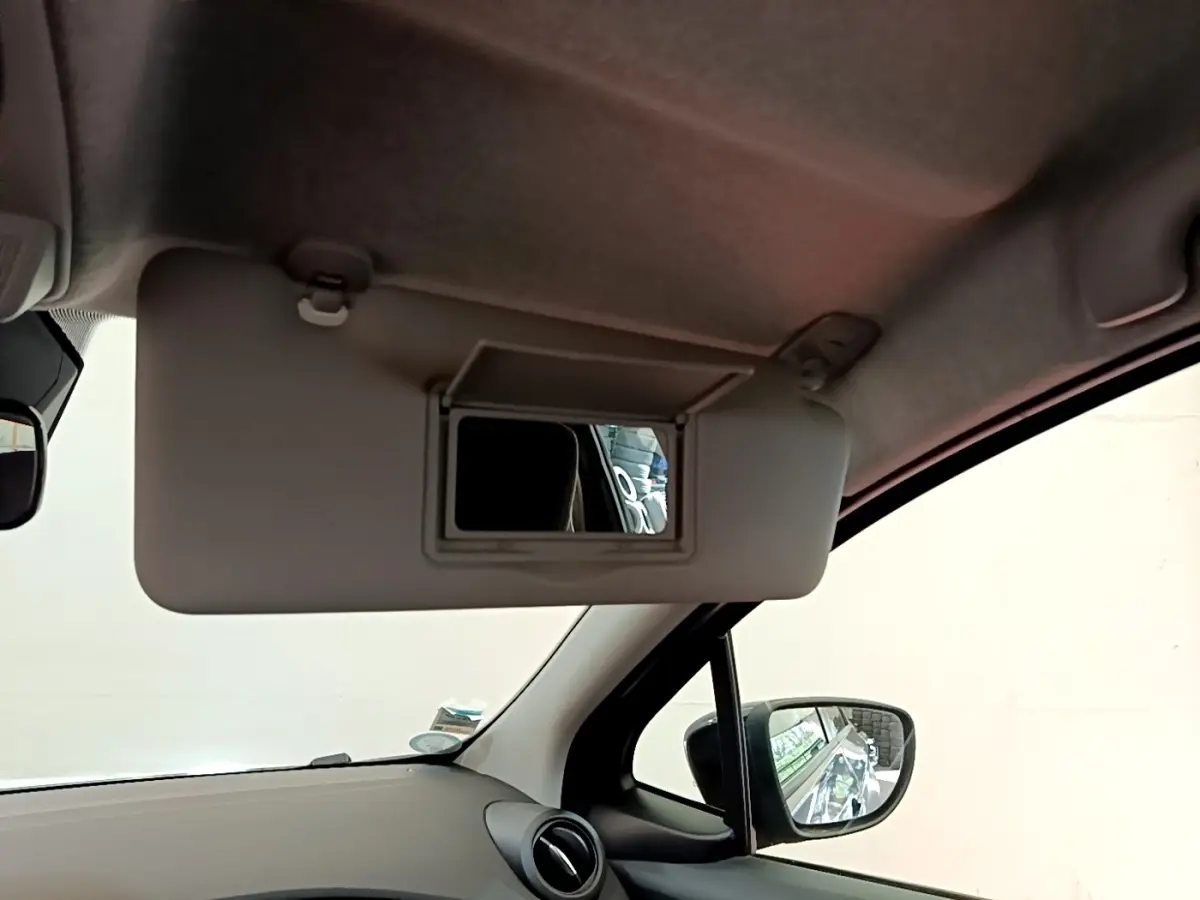 Vue intérieure côté conducteur du pare-soleil avec miroir ouvert dans une Renault ZOE gris clair 2022.