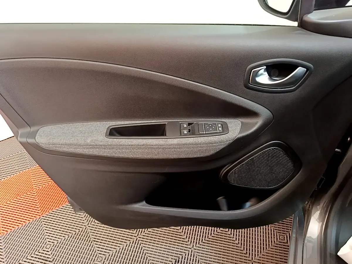 Vue rapprochée de la porte avant gauche gris clair de la Renault ZOE evolution R110 avec commandes électriques et haut-parleur intégré.