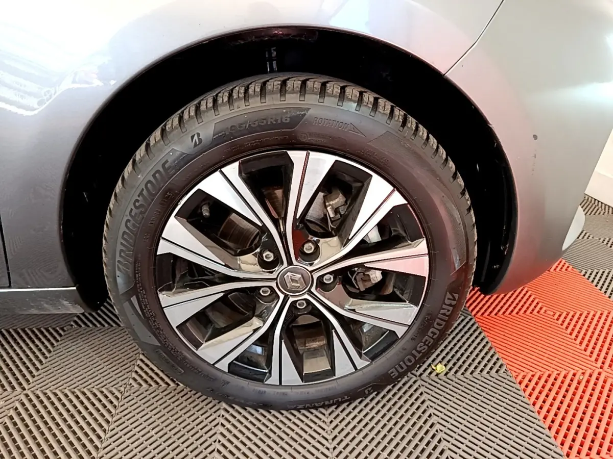 Gros plan sur la roue avant droite de la Renault ZOE gris clair avec jante alliage au design moderne.