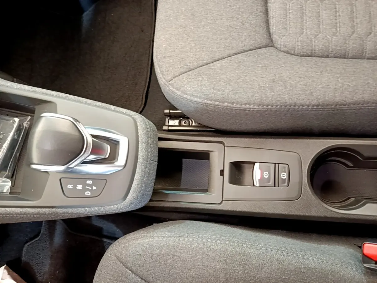 Vue plongeante sur la console centrale grise de la Renault ZOE evolution R110 avec levier de vitesse automatique et frein à main électrique.