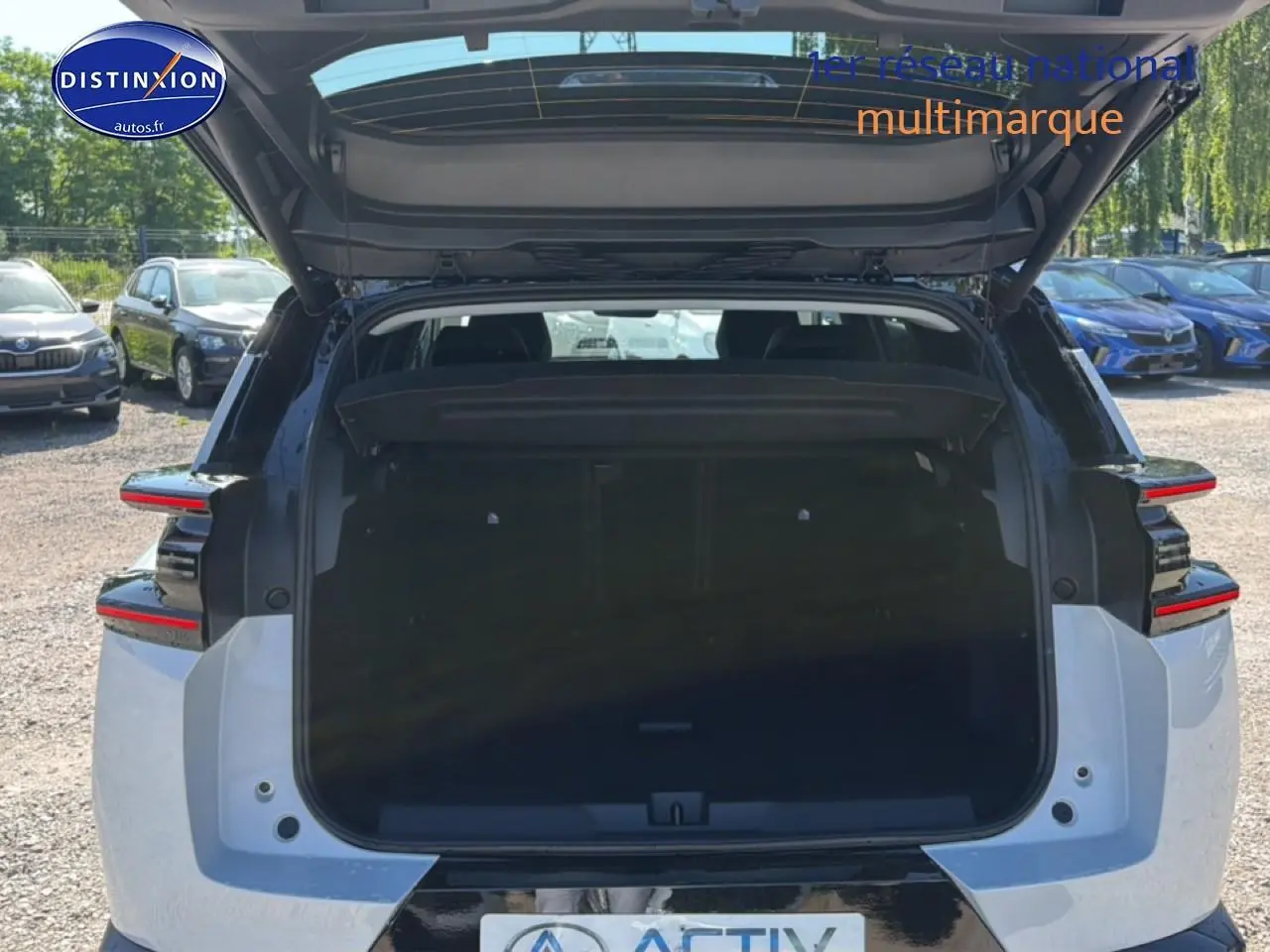 Vue arrière du Citroën C5 Aircross blanc et noir avec hayon ouvert dévoilant le coffre spacieux.