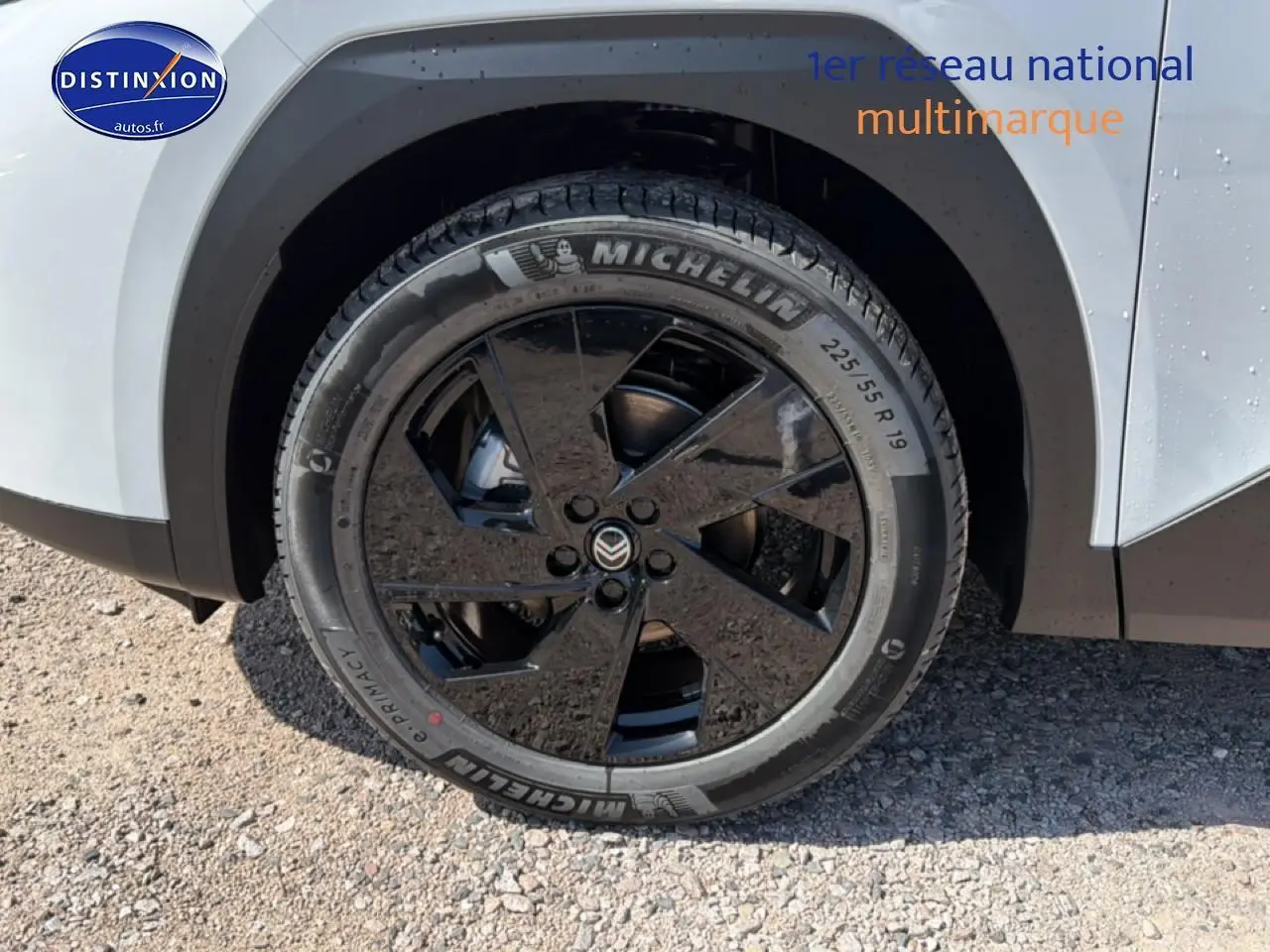 Gros plan sur la roue avant droite noire et jante alliage 19 pouces du Citroën C5 Aircross blanc et noir.