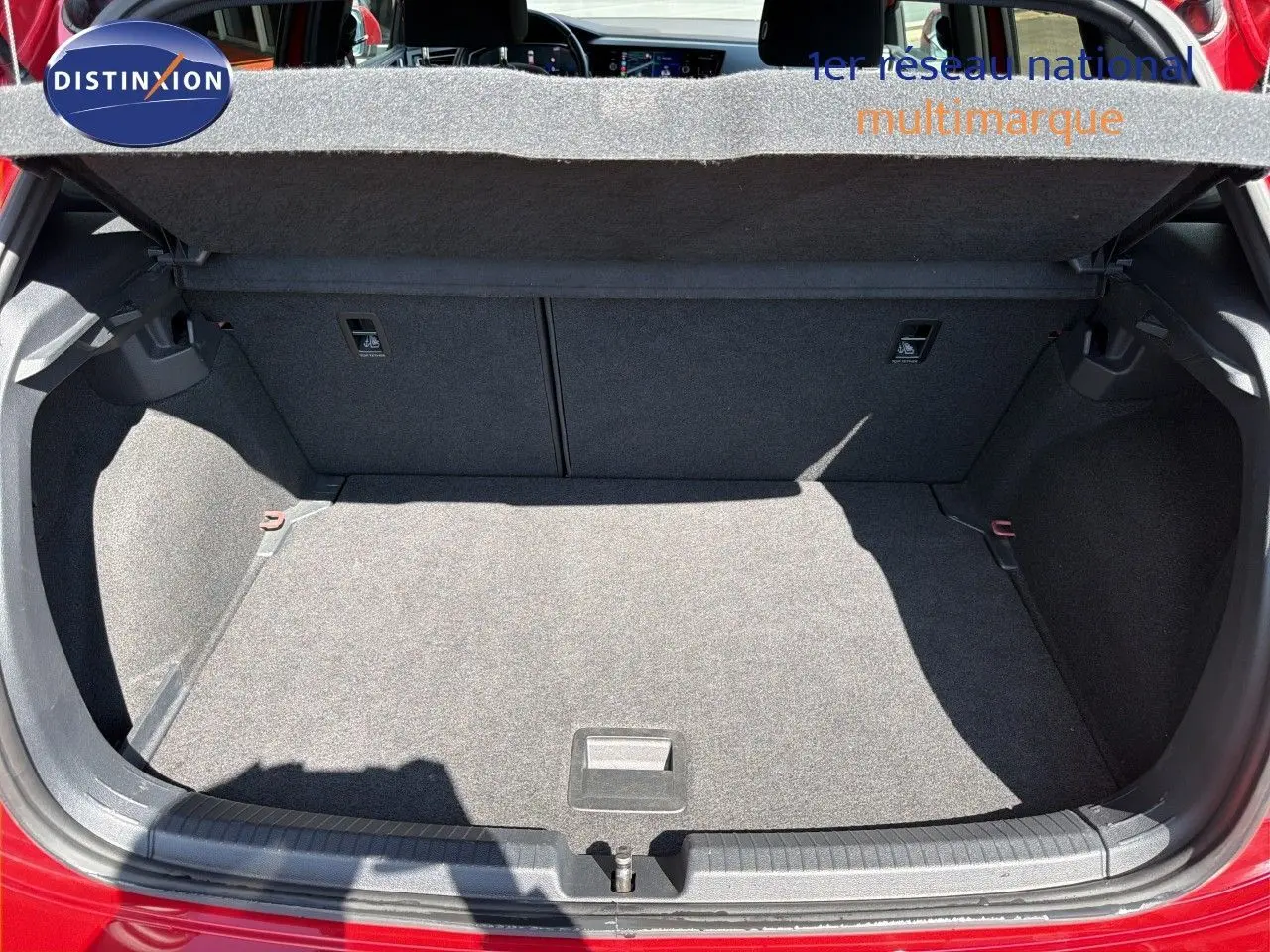 Coffre ouvert vu de l'arrière d'une Volkswagen Polo rouge Roi 2023, montrant l'espace de chargement vide et la plage arrière relevée.