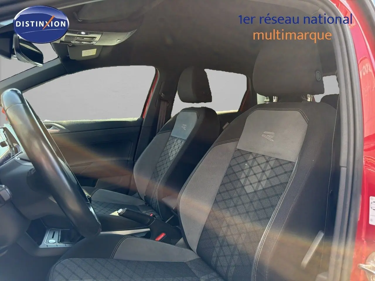 Vue intérieure côté conducteur de la Volkswagen Polo rouge Roi 2023, sièges R-Line avec surpiqûres distinctives.