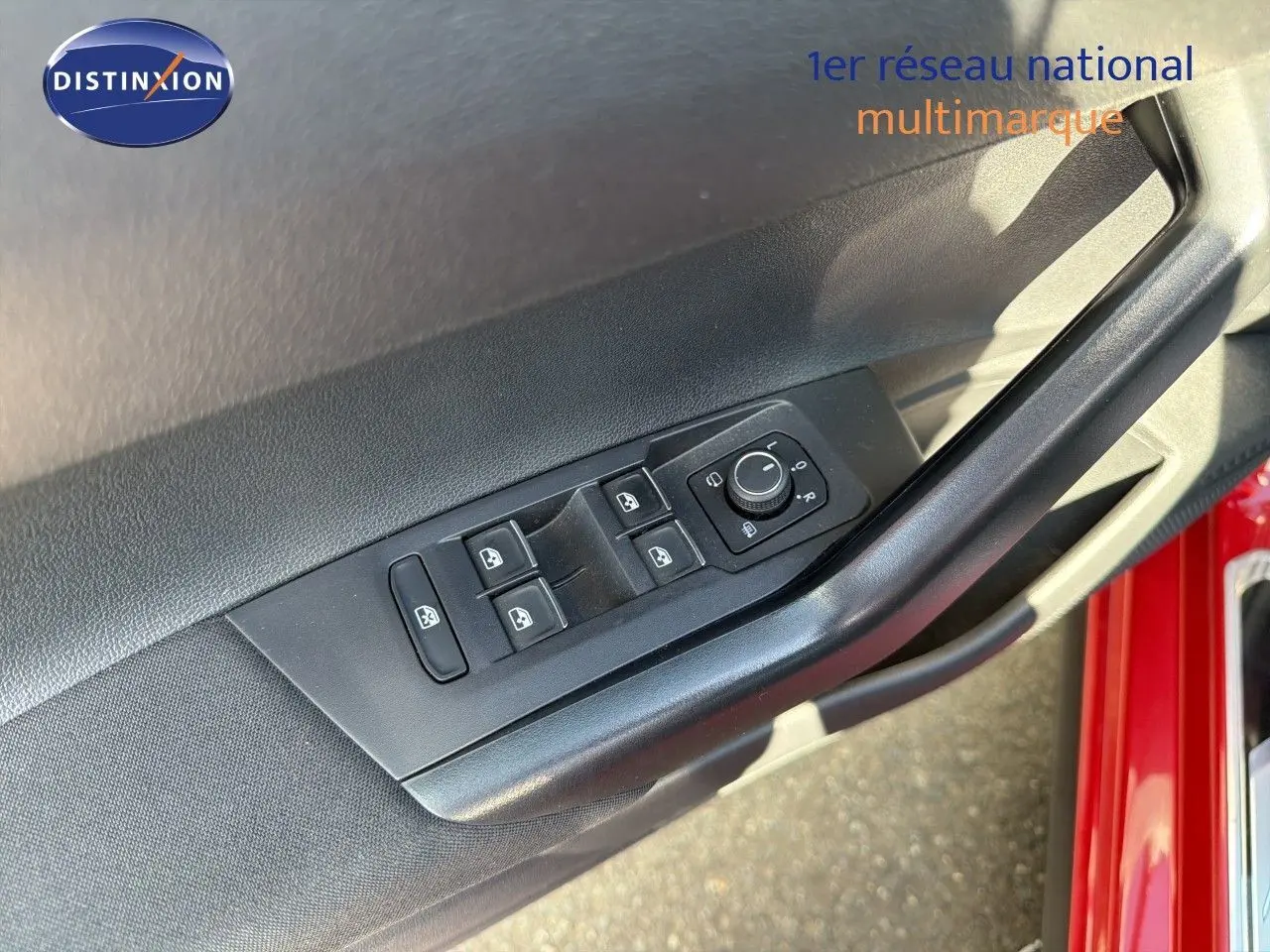 Détail des commandes des vitres et rétroviseurs sur la porte avant gauche d’une Volkswagen Polo rouge Roi 2023.