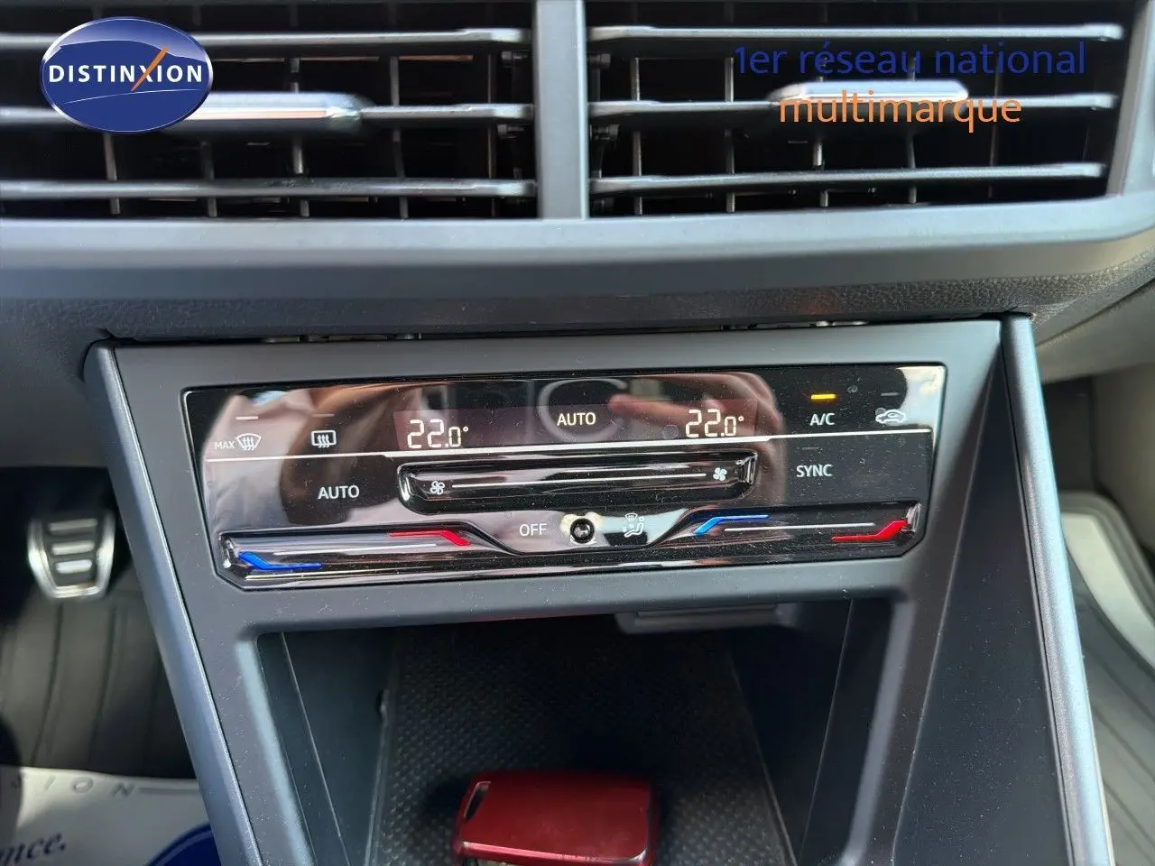 Vue rapprochée du tableau de bord de la Volkswagen Polo rouge Roi 2023, avec commandes de climatisation digitale.