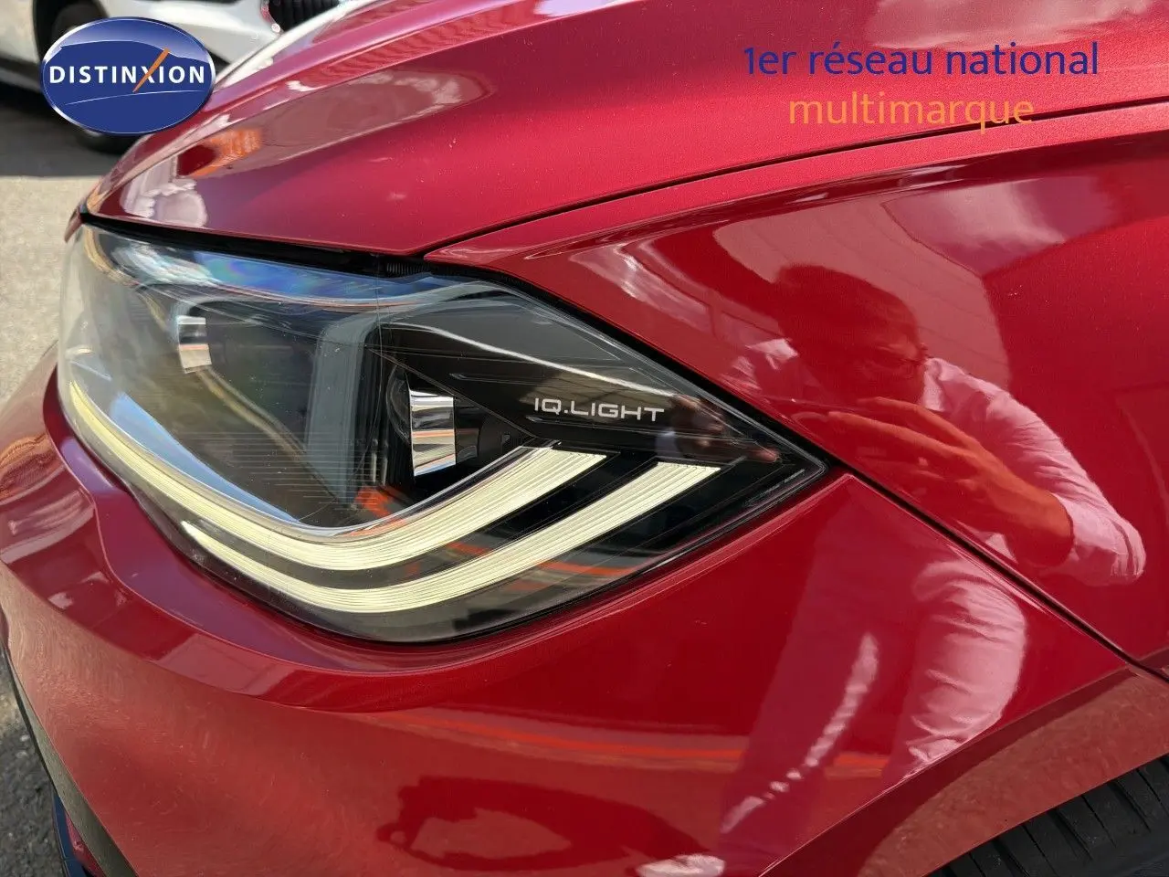 Gros plan sur le phare avant gauche d'une Volkswagen Polo rouge Roi 2023 avec éclairage IQ.Light.