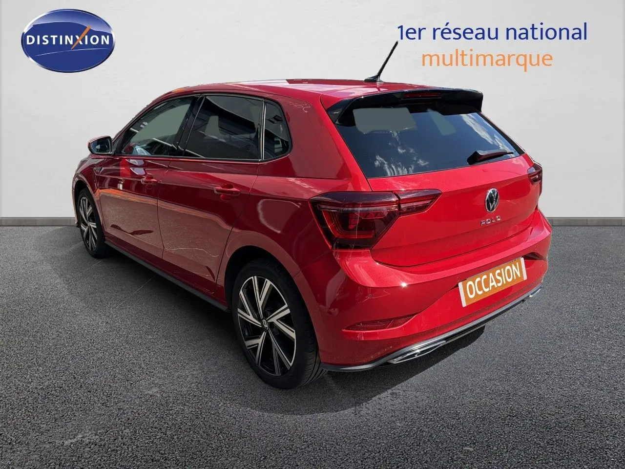 Vue 3/4 arrière droite d'une Volkswagen Polo rouge Roi 2023 finition R-Line avec jantes alliage et vitres teintées.