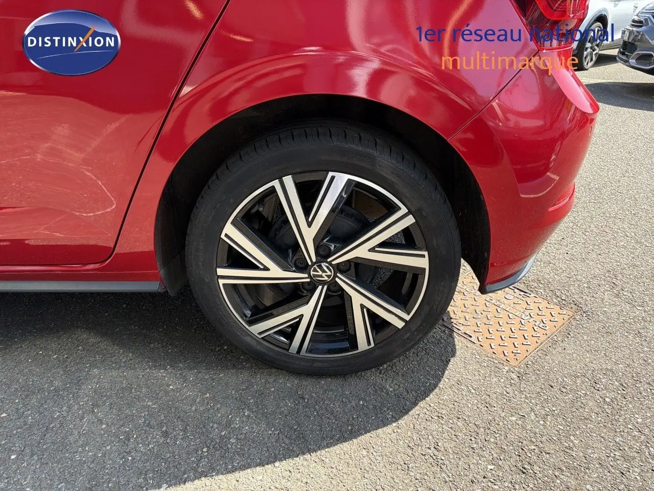 Gros plan sur la roue arrière droite d'une Volkswagen Polo rouge Roi 2023 avec jante alliage noire et argentée.