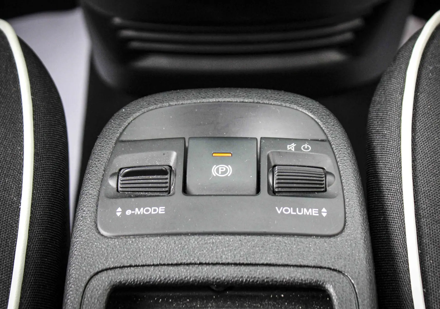 Vue rapprochée du panneau de commandes centrales avec réglages e-Mode et volume dans une Fiat 500 électrique gris minéral.