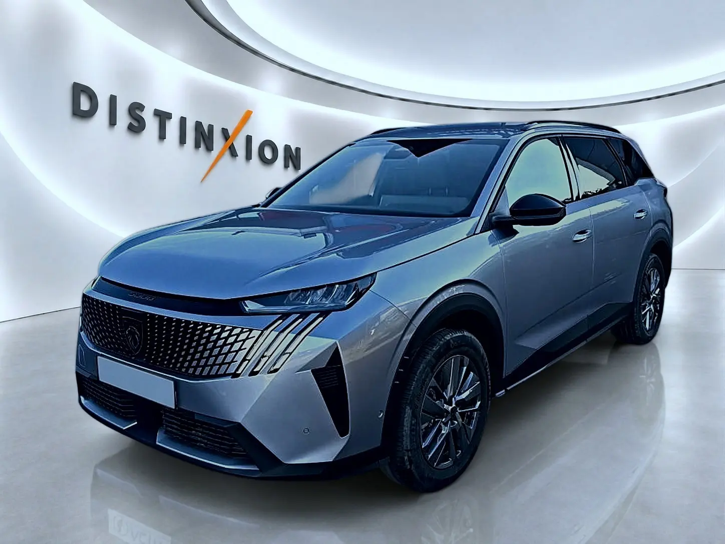 Peugeot 5008 Hybrid 145 allure e-dcs6 gris artense en 3/4 avant droit dans un showroom lumineux.