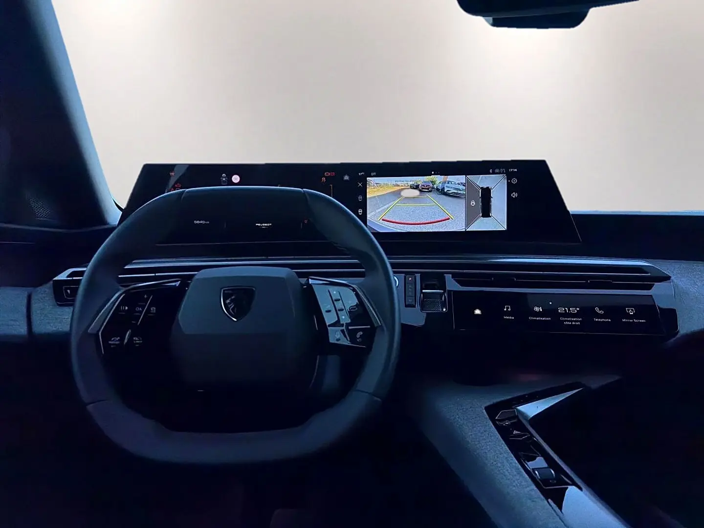 Vue intérieure du tableau de bord et volant cuir noir du Peugeot 5008 Hybrid 145 allure e-dcs6 avec écran tactile et affichage caméra de recul.