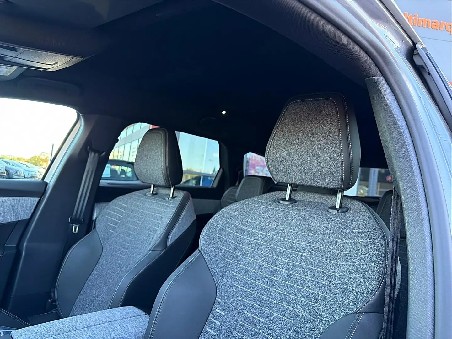 Vue intérieure des sièges avant gris tissu et cuir du Peugeot 5008 Hybrid 145 allure e-dcs6 2025, côté droit.