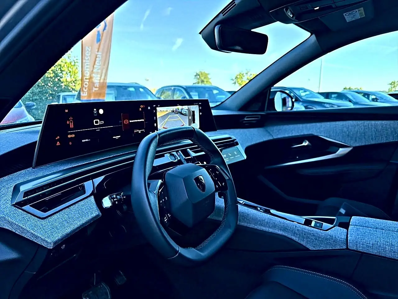 Vue intérieure côté conducteur du Peugeot 5008 Hybrid 145 allure e-dcs6 2025, tableau de bord et volant cuir multifonction.