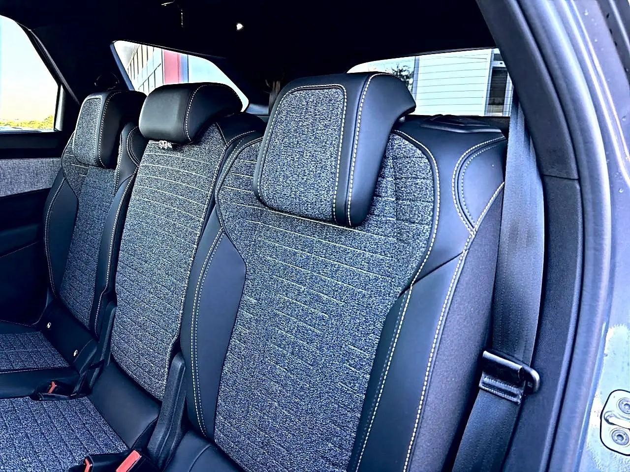 Vue intérieure des sièges arrière en tissu gris et cuir noir du Peugeot 5008 Hybrid 145 allure e-dcs6 2025.