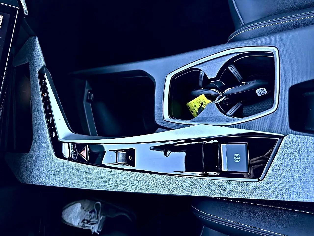 Vue rapprochée de la console centrale grise et noire du Peugeot 5008 Hybrid 145 allure e-dcs6 avec porte-gobelets et commandes.