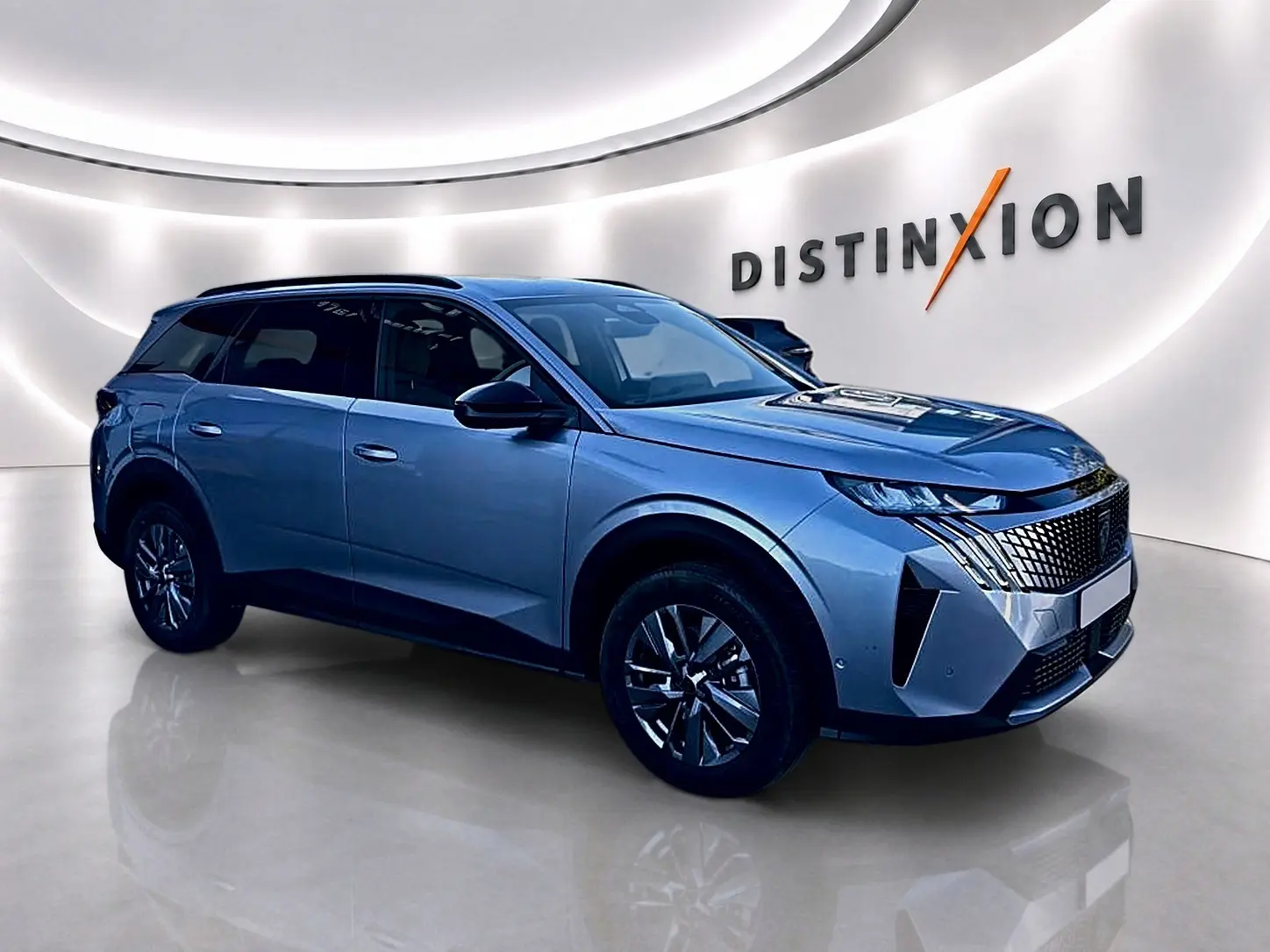 Peugeot 5008 Hybrid 145 allure e-dcs6 gris artense en 3/4 avant droit dans un showroom lumineux.