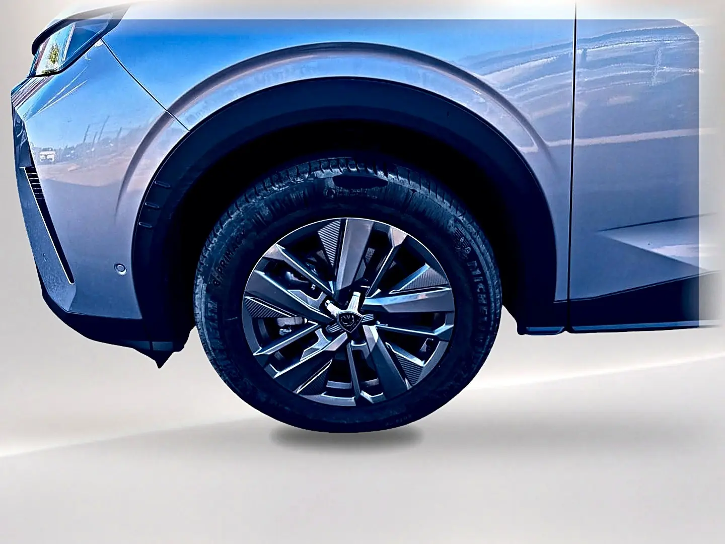 Gros plan sur la roue avant droite et l'aile gris artense du Peugeot 5008 Hybrid 145 allure e-dcs6 2025.
