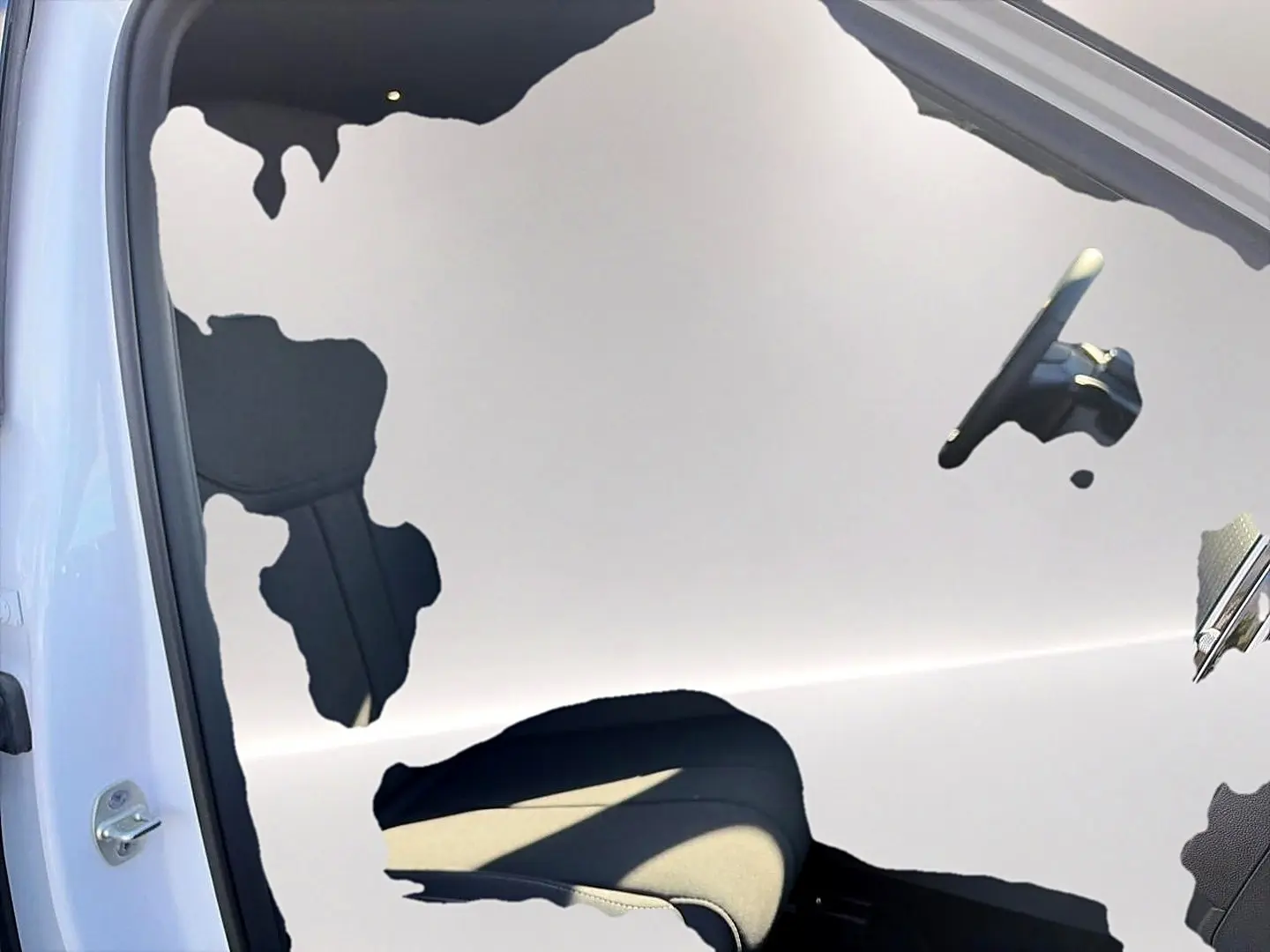 Reflet du siège conducteur et du volant dans la portière ouverte d'un JAECOO J7 blanc kaki.