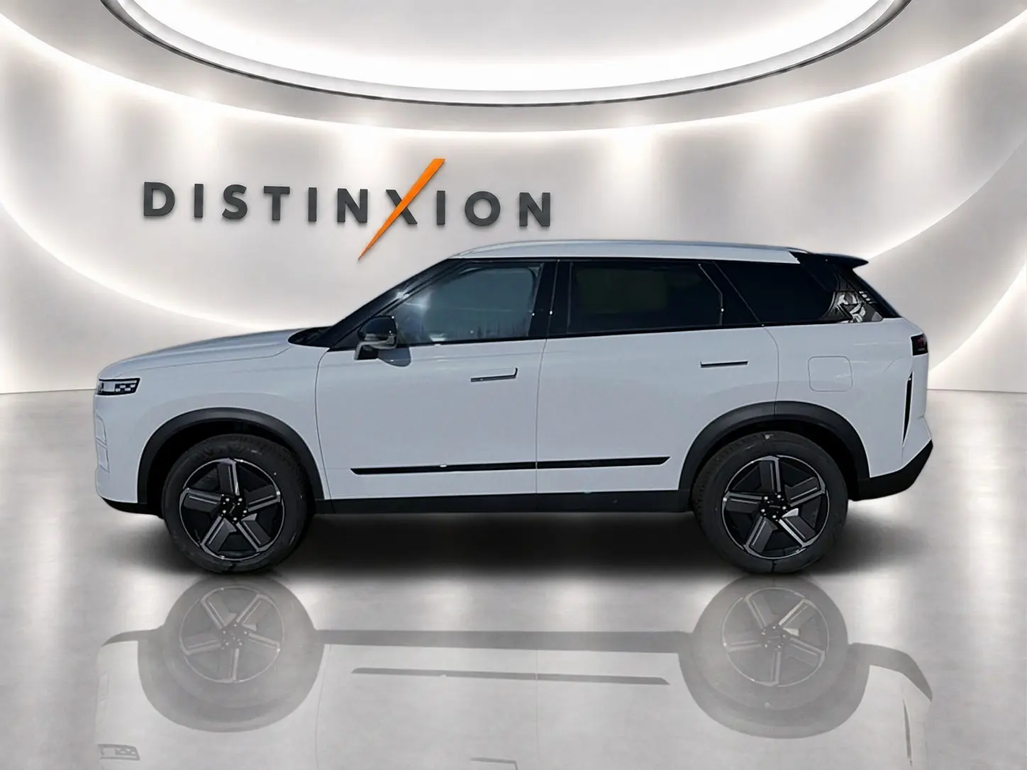 Vue de profil droit du SUV JAECOO J7 blanc kaki avec toit noir et jantes alu noires dans un showroom lumineux.