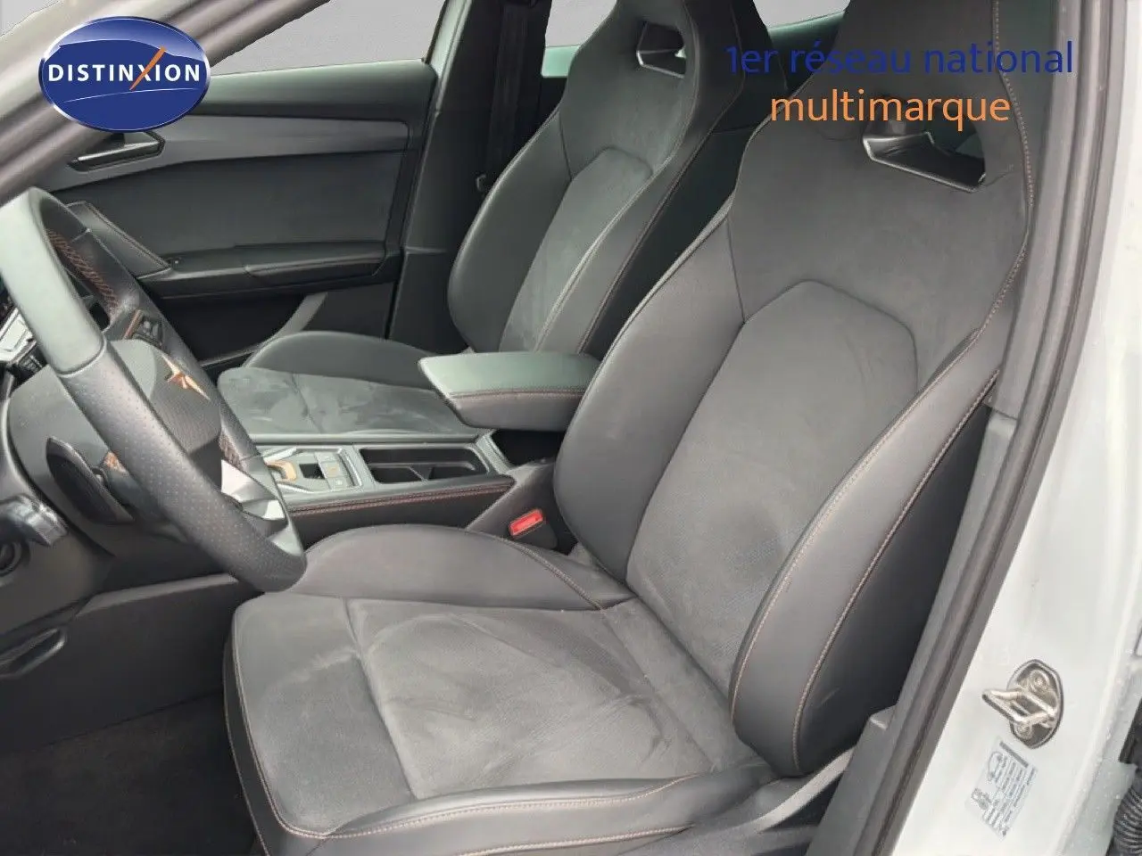 Vue intérieure côté conducteur de la CUPRA Formentor blanc neige, sièges sport en cuir et alcantara avec surpiqûres orange.