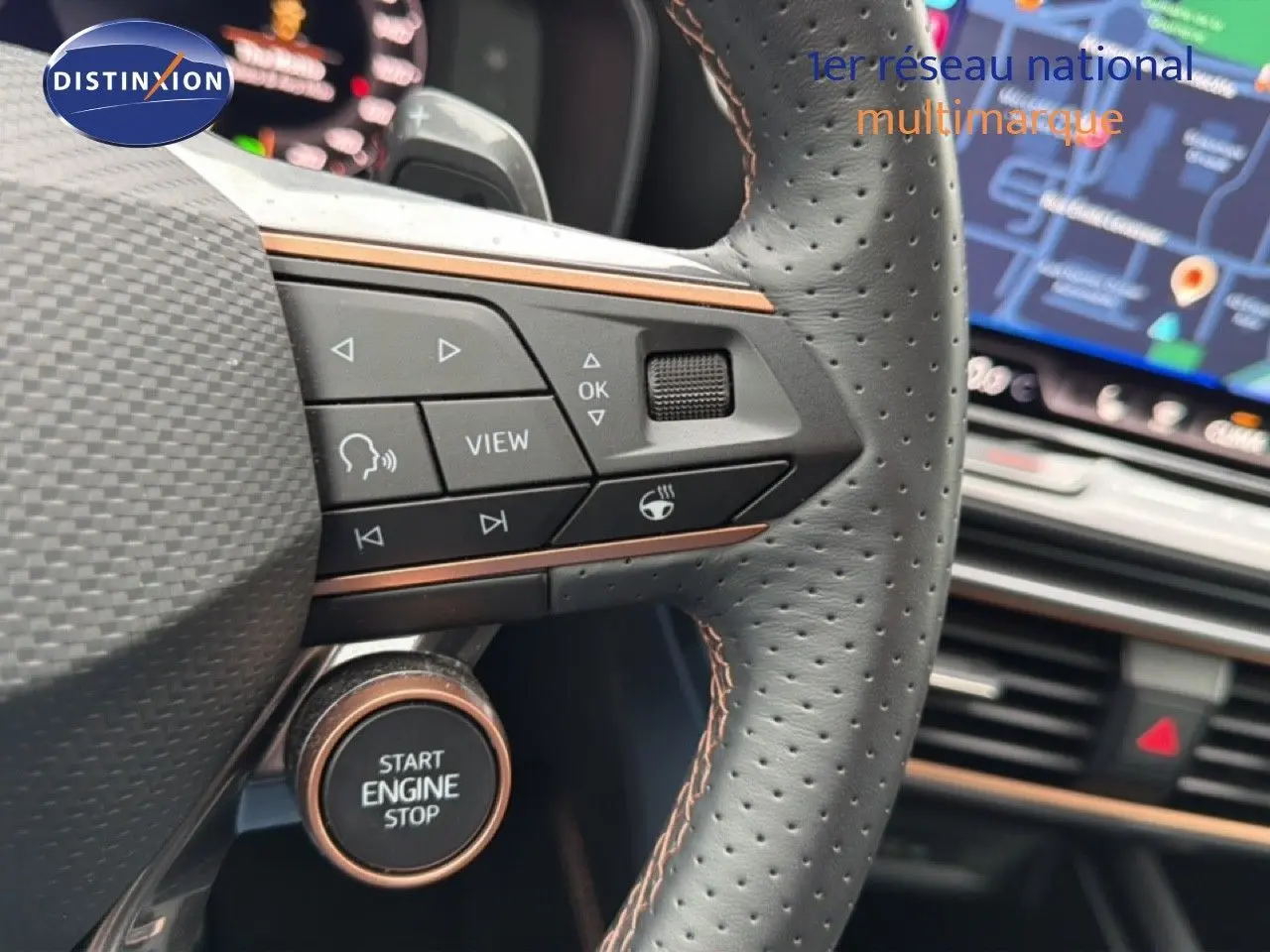 Gros plan sur le volant perforé noir avec commandes intégrées et bouton start/stop cuivré du CUPRA Formentor blanc neige 2025.