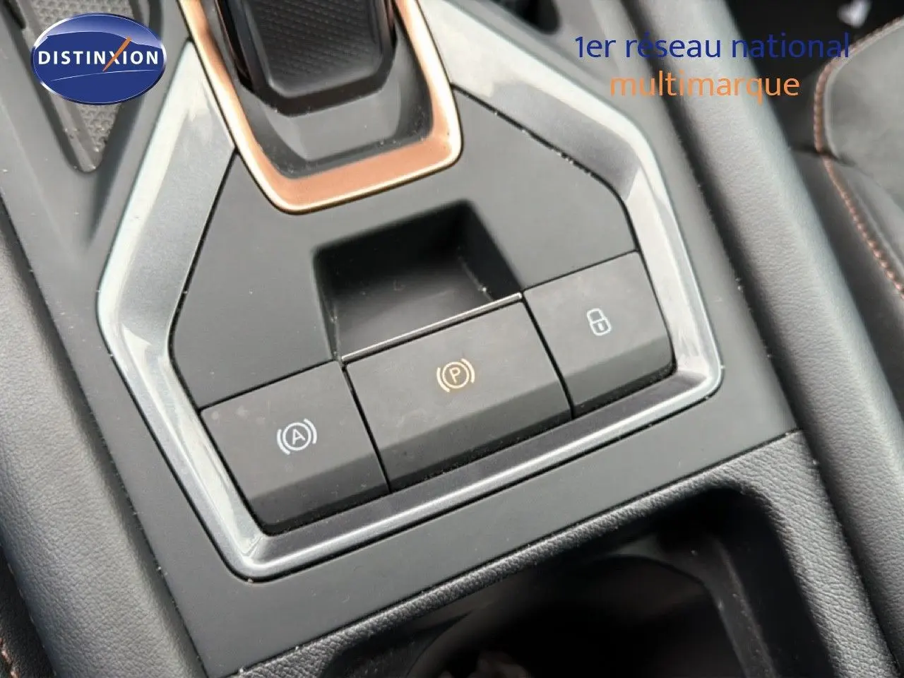 Gros plan sur la console centrale du CUPRA Formentor 1.5 eTSI 150CH DSG7, montrant les boutons de frein à main et verrouillage.