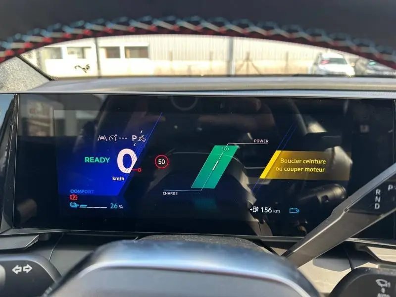 Tableau de bord numérique du Renault Scénic E-Tech gris, affichant la vitesse à 0 km/h et l'autonomie restante.