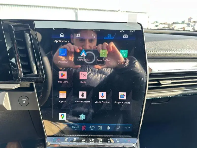 Écran tactile central du tableau de bord du Renault Scenic E-Tech gris, avec interface multimédia visible.