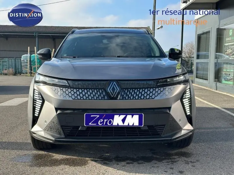 Vue avant du Renault Scénic E-Tech électrique gris schiste avec signature lumineuse verticale LED et calandre hexagonale.