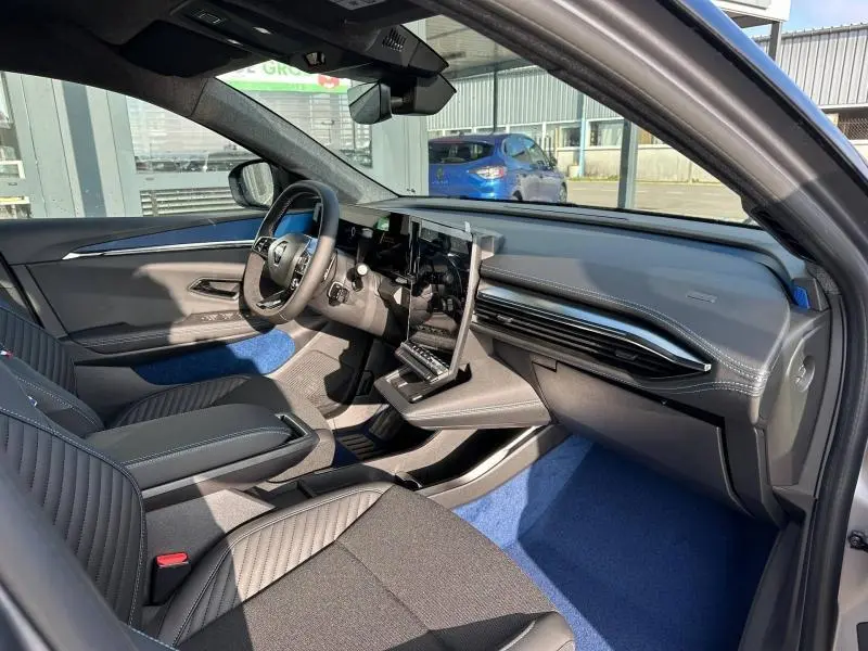 Intérieur avant droit du Renault Scénic E-Tech gris Schiste 2025 avec sièges sport et écran tactile vertical.