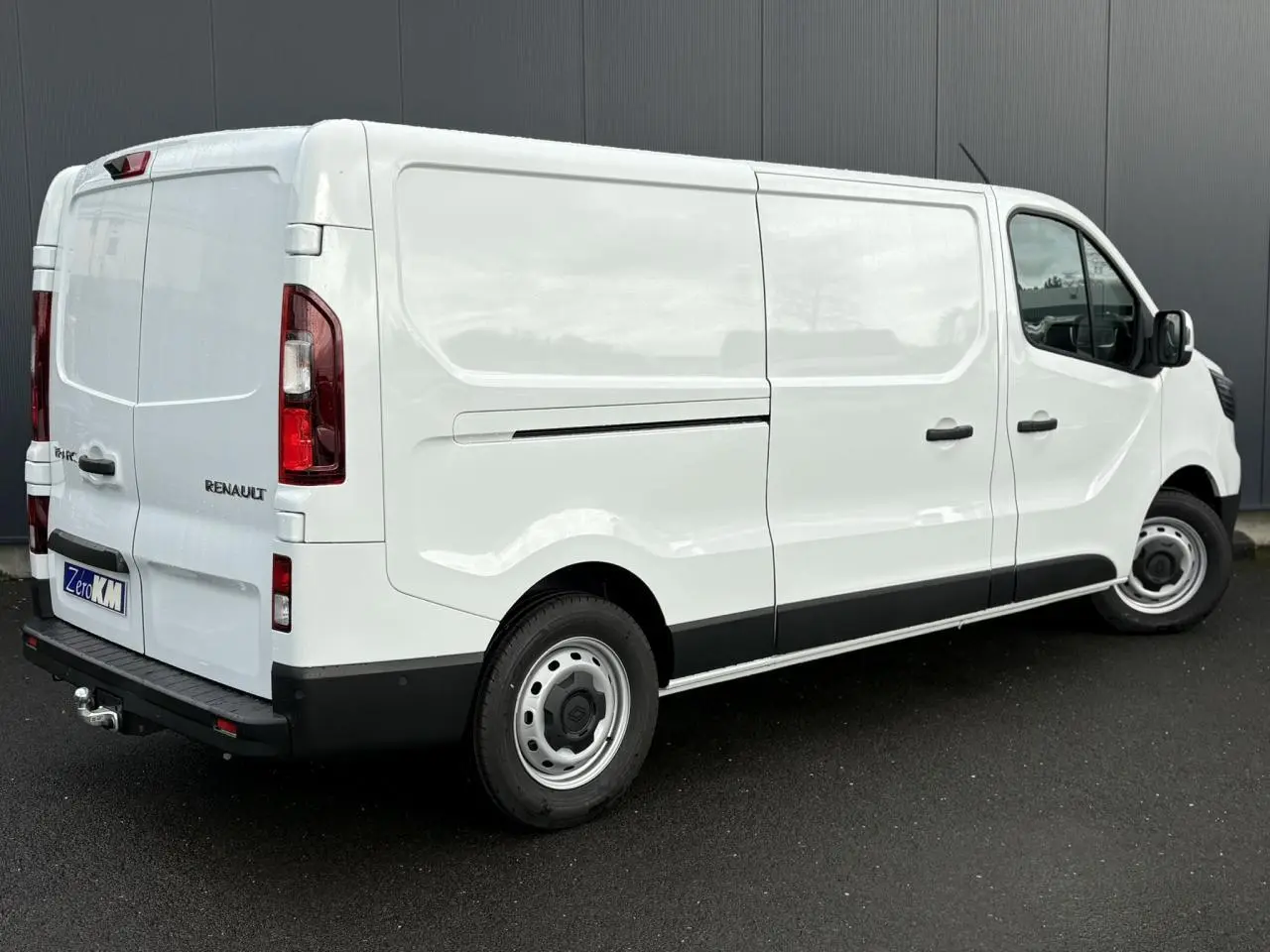 Vue 3/4 arrière droite du Renault Trafic Fourgon blanc Glacier avec attelage et porte latérale coulissante.