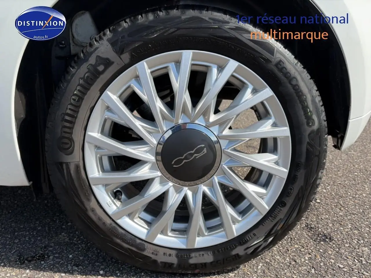 Gros plan sur la jante alu argentée et le pneu Continental d'une FIAT 500 blanche, côté avant droit.