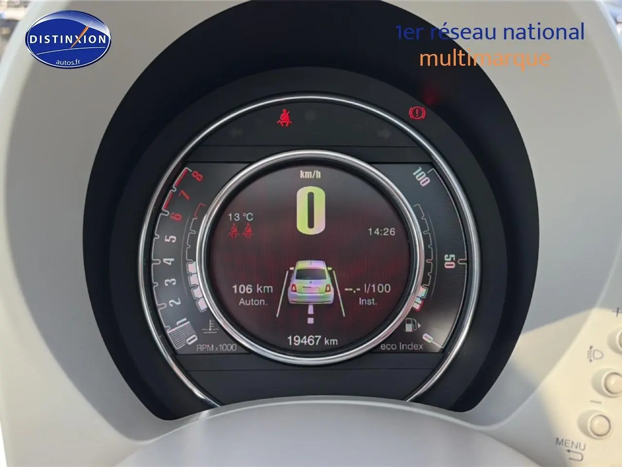 Vue rapprochée du tableau de bord numérique du Fiat 500 blanc, affichant le compteur et les alertes de sécurité.