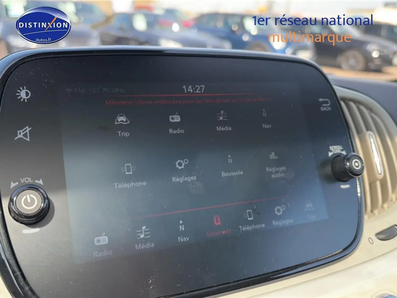 Écran tactile central de la Fiat 500 blanc, affichant le menu multimédia avec commandes autour, vue intérieure rapprochée.