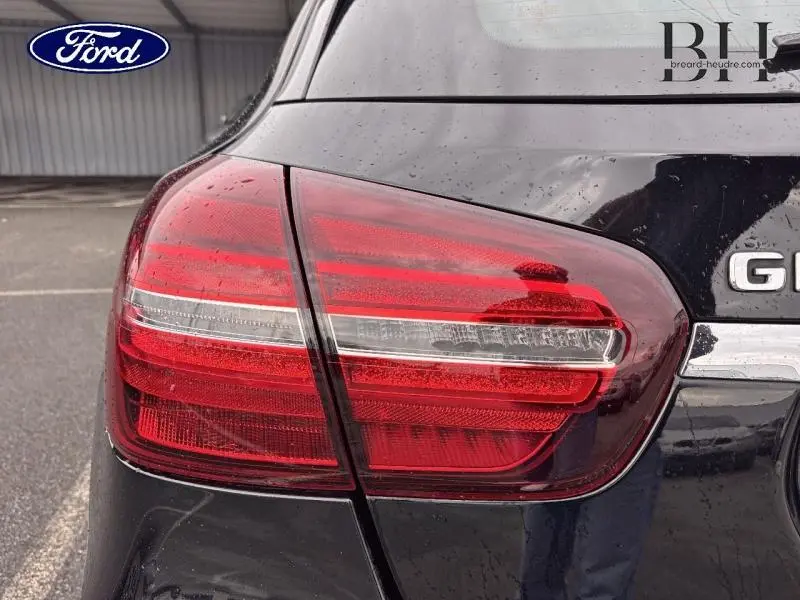 Gros plan sur le feu arrière gauche rouge d’un Mercedes GLA 180 d Fascination noir cosmos de 2018.