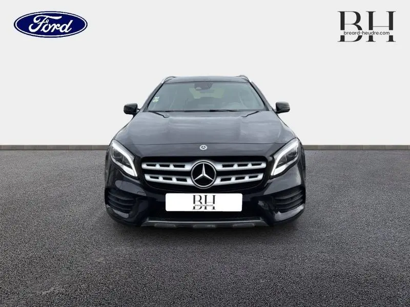 Vue avant d'une Mercedes GLA 180 d Fascination 2018 noir cosmos avec calandre chromée et phares LED allumés.