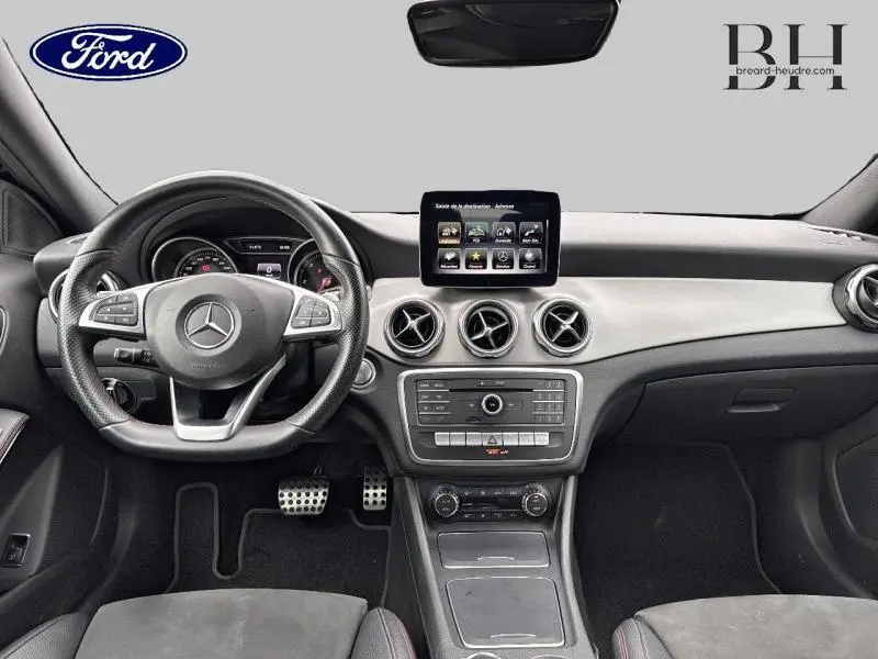 Vue intérieure avant du tableau de bord noir et gris clair de la Mercedes GLA 180 d Fascination avec écran central et volant multifonction.