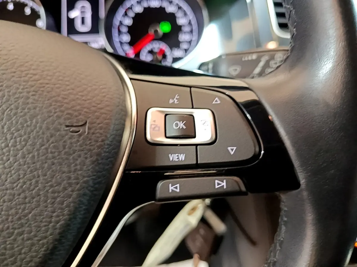 Gros plan sur le volant cuir noir multifonctions de la Volkswagen Golf 1.0 TSI 115 DSG7 Connect, avec commandes intégrées.